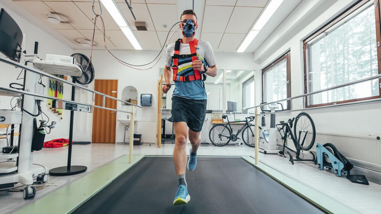 Juokseva henkilö hengitysmaski kasvoillaan laboratoriossa.