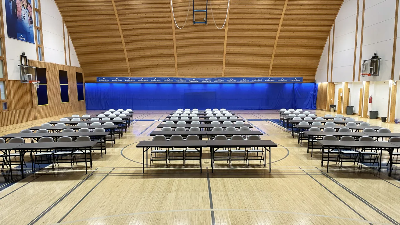 Kisakallion Pallohallissa riveittäin pöytiä ja tuoleja.