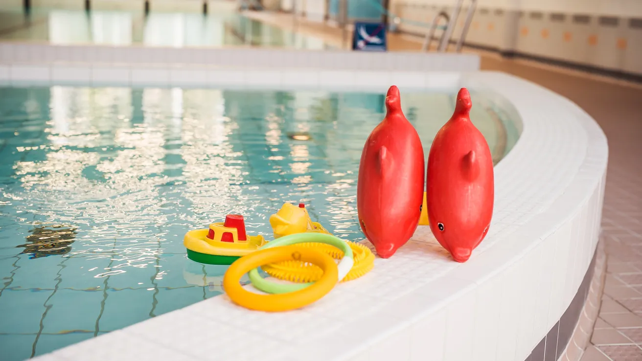 Uimahalli Pajulahdessa. Kellukkeita ja leluja altaan reunalla.