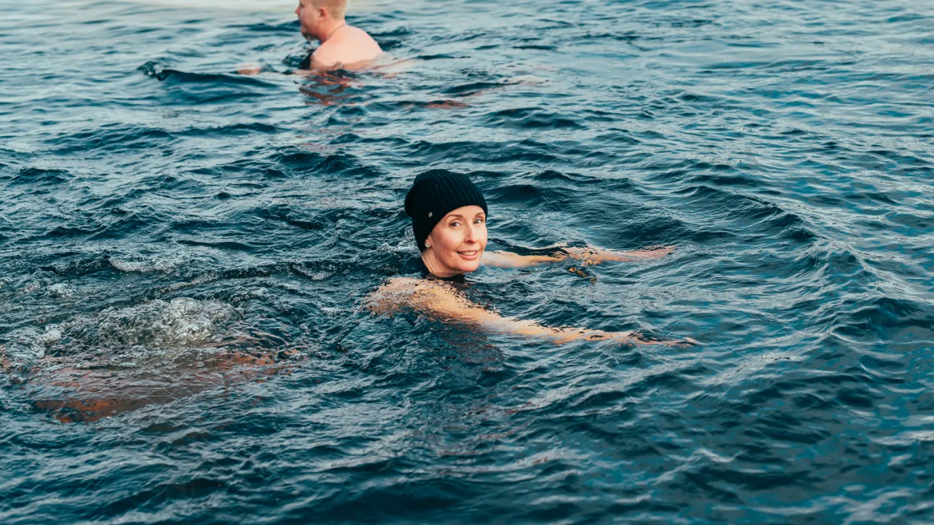 Kaksi ihmistä ui avannossa.