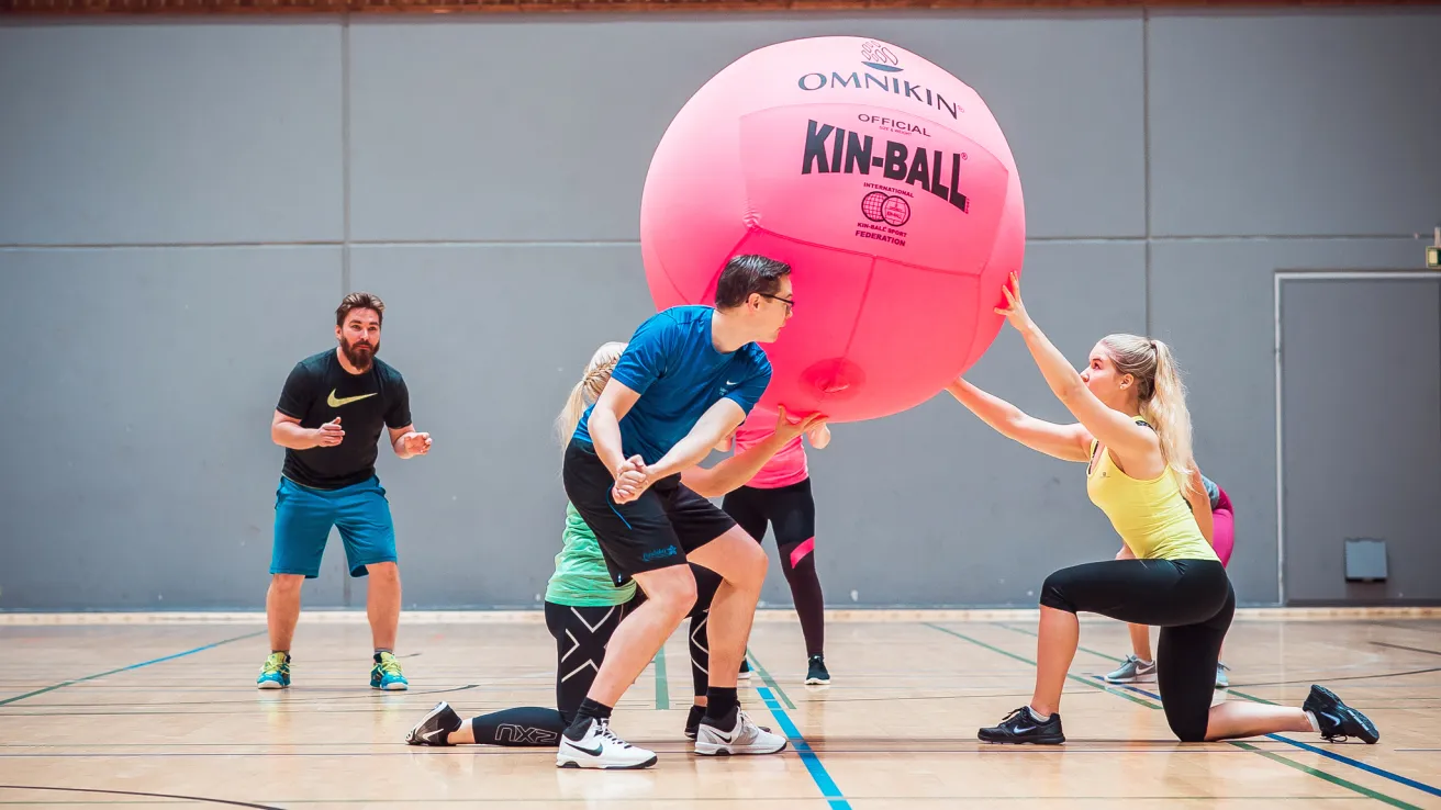 Aikuiset pelaavat KIN-Ballia salissa.