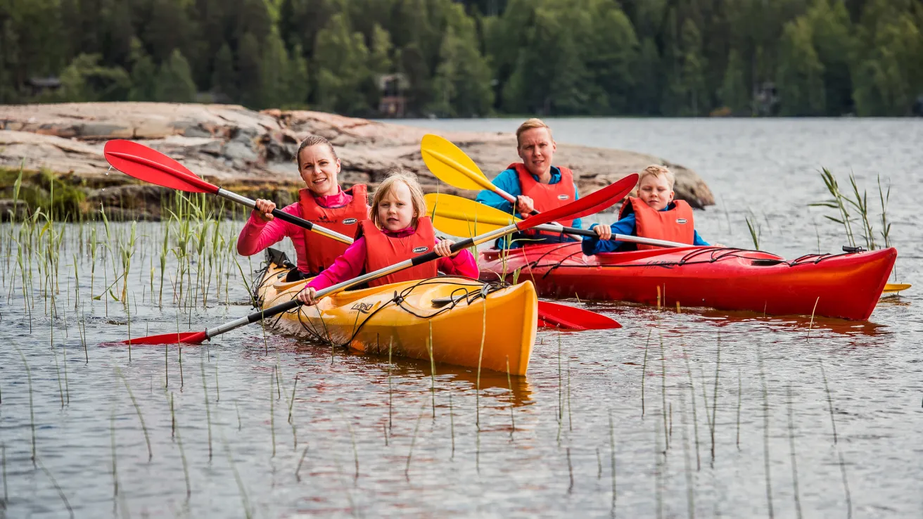 Perhe melomassa kanooteilla Pajulahdessa Iso-Kukkasen järvessä.