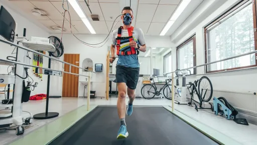 Juokseva henkilö hengitysmaski kasvoillaan laboratoriossa.