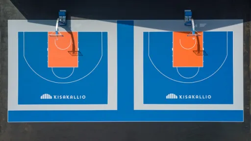 Kaksi vierekkäistä koripallokenttää, sininen alusta ja oranssit maalialueet.