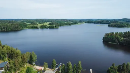 Lohjanjärvi metsäisessä maisemassa, sininen taivas, valokuva.