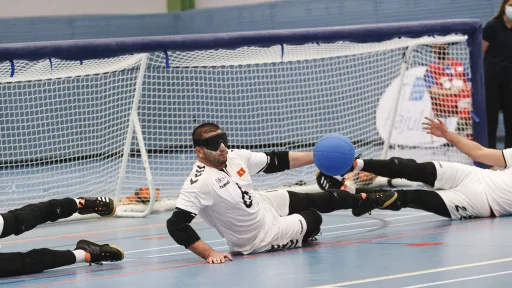 Urheilijat maalipallopelissä sisähallissa.