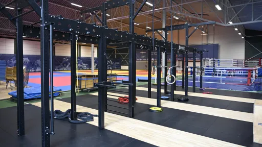 Sisäsali, jossa on kuntosalilaitteita ja voimistelumattoja.