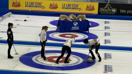 Curling-joukkue harjoituksissa jäällä, värikäs logo taustalla.