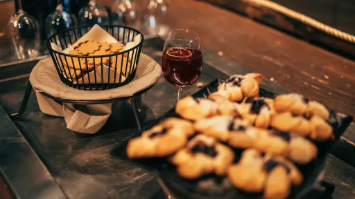 Rantamakasiinin tarjoilupöydällä pipareita korissa, joulutorttuja ja glögiä.