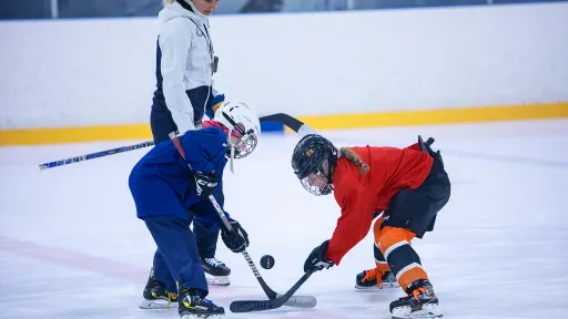 Susanna Tapani opastamassa tyttökiekkoilijoita jäällä