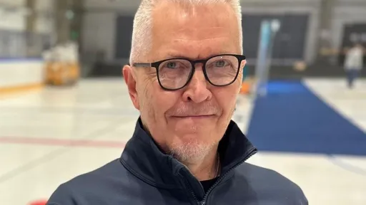 Kuvassa Asko Härkönen mustissa silmälaseissa ja tummassa takissa sisätilassa.