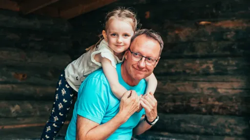 Isä ja tyttö hymyilevät laavulla.