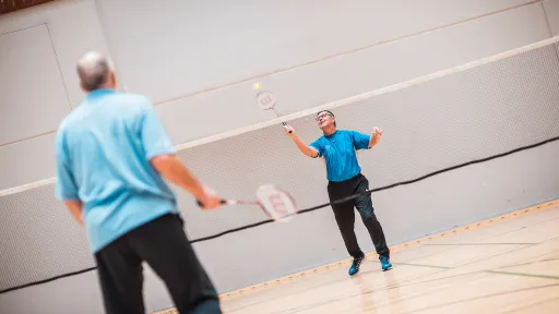 Kaksi miestä pelaa sulkapalloa.