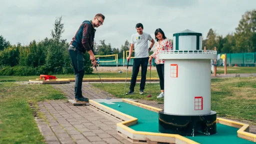 Pajulahden uudistetulla minigolf-kentällä pelaa kaksi miestä ja nainen