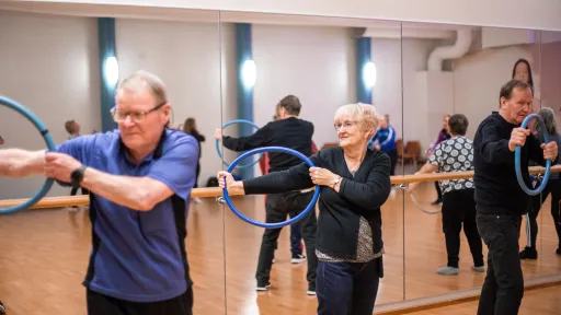 Aikuiset 60+ Kisakallion Peilisalissa vanteen kanssa.