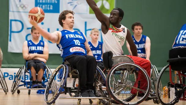 Wheelchair basketball game, players reaching for a ball.