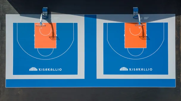 Kaksi vierekkäistä koripallokenttää, sininen alusta ja oranssit maalialueet.