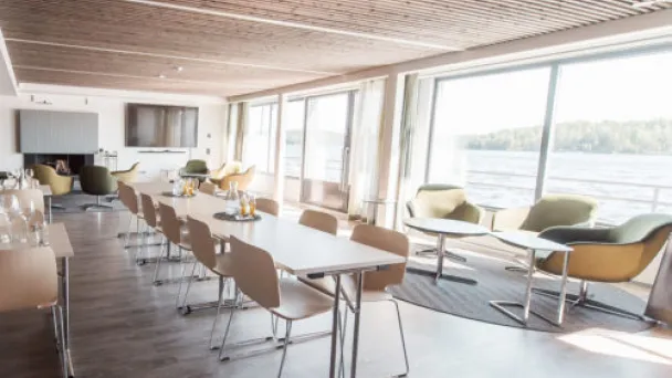 Tilava ja valoisa kokoushuone, suuret ikkunat ja järvinäköala.