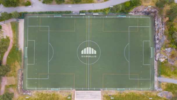 Jalkapallokenttä ylhäältä, ympärillä vihreää kasvillisuutta.