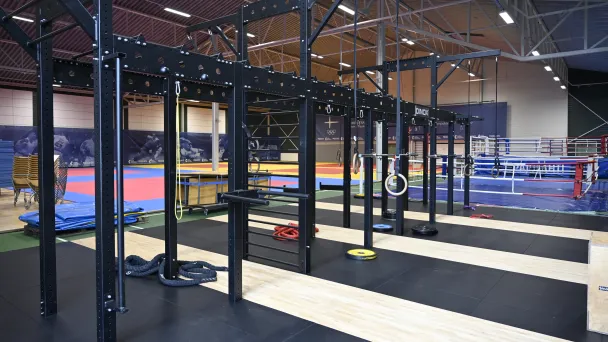 Sisäsali, jossa on kuntosalilaitteita ja voimistelumattoja.