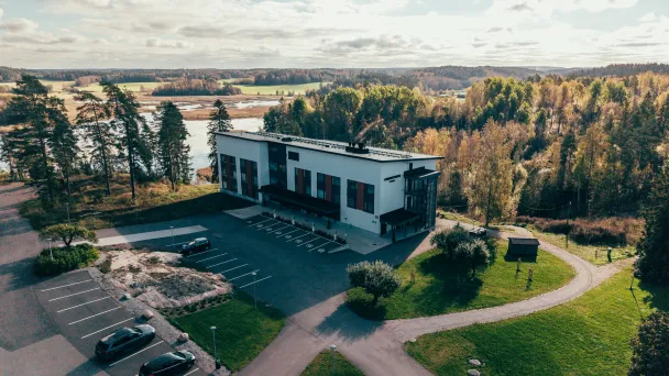 Hotelli Omenatarha vehreän metsän reunalla, lähellä vettä.