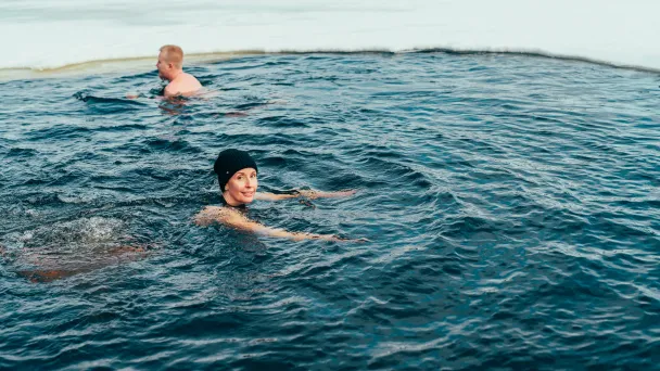 Kaksi ihmistä ui avannossa Pajulahdessa.