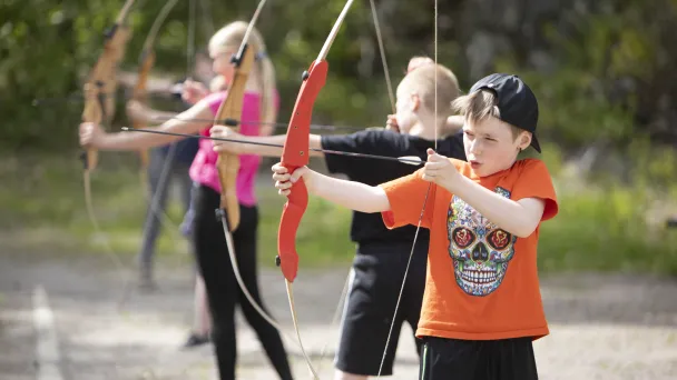 Lapset harjoittelemassa jousiammuntaa