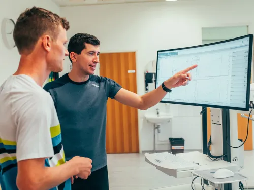 Kaksi miestä keskustelemassa tietokoneen näytön edessä.