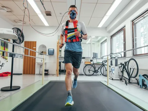 Juokseva henkilö hengitysmaski kasvoillaan laboratoriossa.