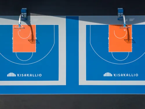 Kaksi vierekkäistä koripallokenttää, sininen alusta ja oranssit maalialueet.