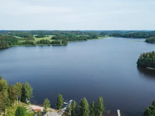 Lohjanjärvi metsäisessä maisemassa, sininen taivas, valokuva.