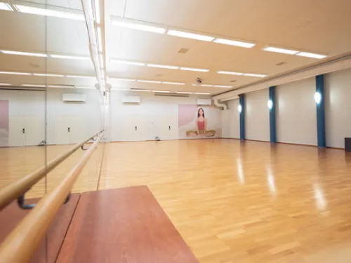 Tyhjä tanssisali, peiliseinä, vaaleat lattiat.