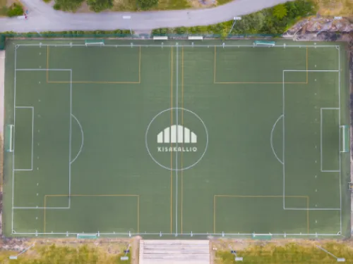 Jalkapallokenttä ylhäältä, ympärillä vihreää kasvillisuutta.