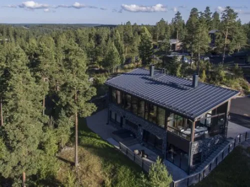 Moderni talo metsäisessä ympäristössä, aurinkoinen sää.