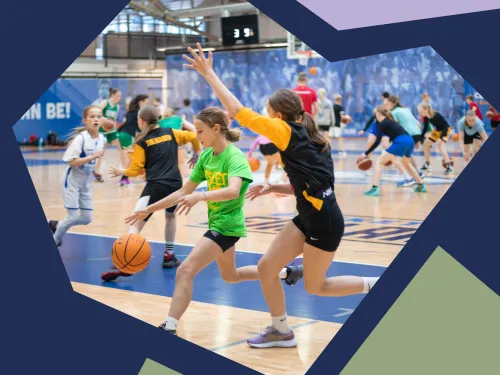 Koripallopeli sisätiloissa, lapset juoksevat pallon kanssa.