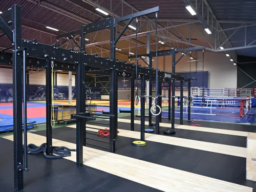 Sisäsali, jossa on kuntosalilaitteita ja voimistelumattoja.