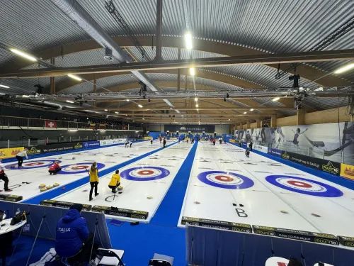 Curling-halli, jossa useita kenttiä ja pelaajia.