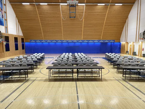 Kisakallion Pallohallissa riveittäin pöytiä ja tuoleja.