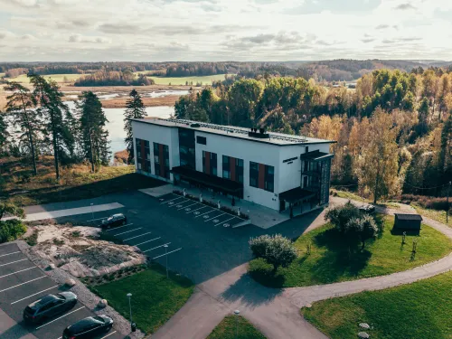 Hotelli Omenatarha vehreän metsän reunalla, lähellä vettä.