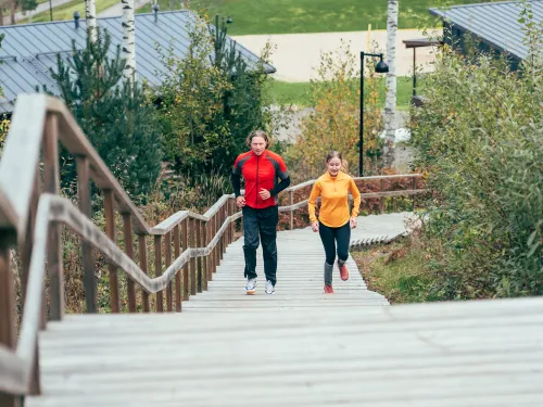 Mies ja nainen hölkkäävät Kisakallion kuntoportaita.