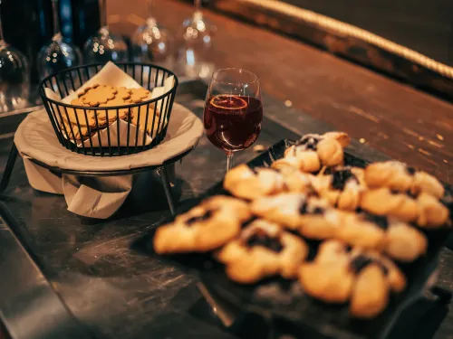 Rantamakasiinin tarjoilupöydällä pipareita korissa, joulutorttuja ja glögiä.