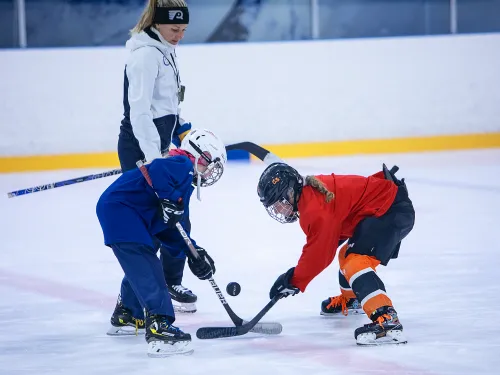 Susanna Tapani opastamassa tyttökiekkoilijoita jäällä