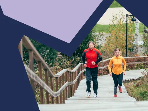 Mies ja nainen hölkkäävät Kisakallion kuntoportaita ylöspäin.