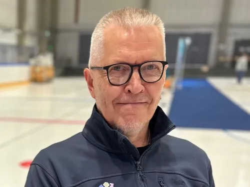 Kuvassa Asko Härkönen mustissa silmälaseissa ja tummassa takissa sisätilassa.