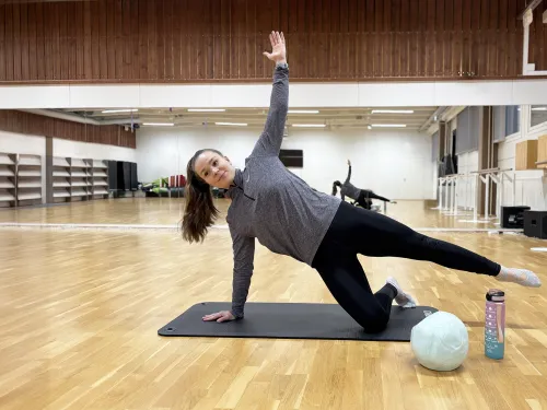 Nainen joogaa jumppamatolla Pajulahden Tanssistudiossa