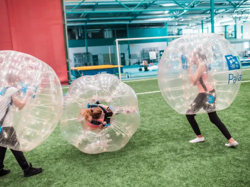 Kolme lasta pelaamassa kuplafutista Pajulahti-hallissa.