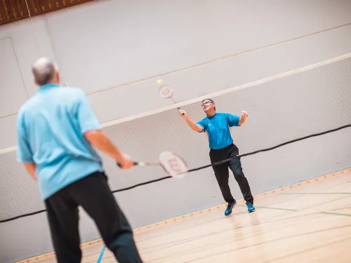 Kaksi miestä pelaa sulkapalloa.