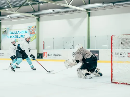 Jääkiekkoilija lähestyy maalivahtia kiekko lavassa.