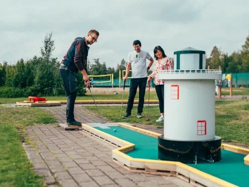 Pajulahden uudistetulla minigolf-kentällä pelaa kaksi miestä ja nainen