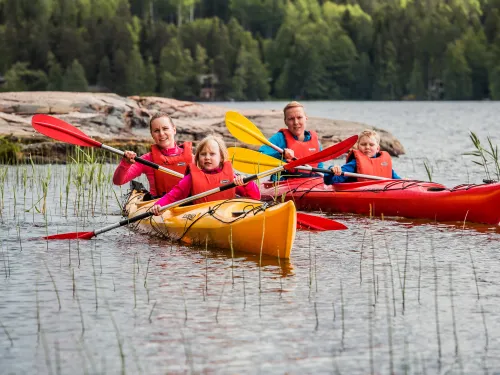 Perhe melomassa kanooteilla Pajulahdessa Iso-Kukkasen järvessä.